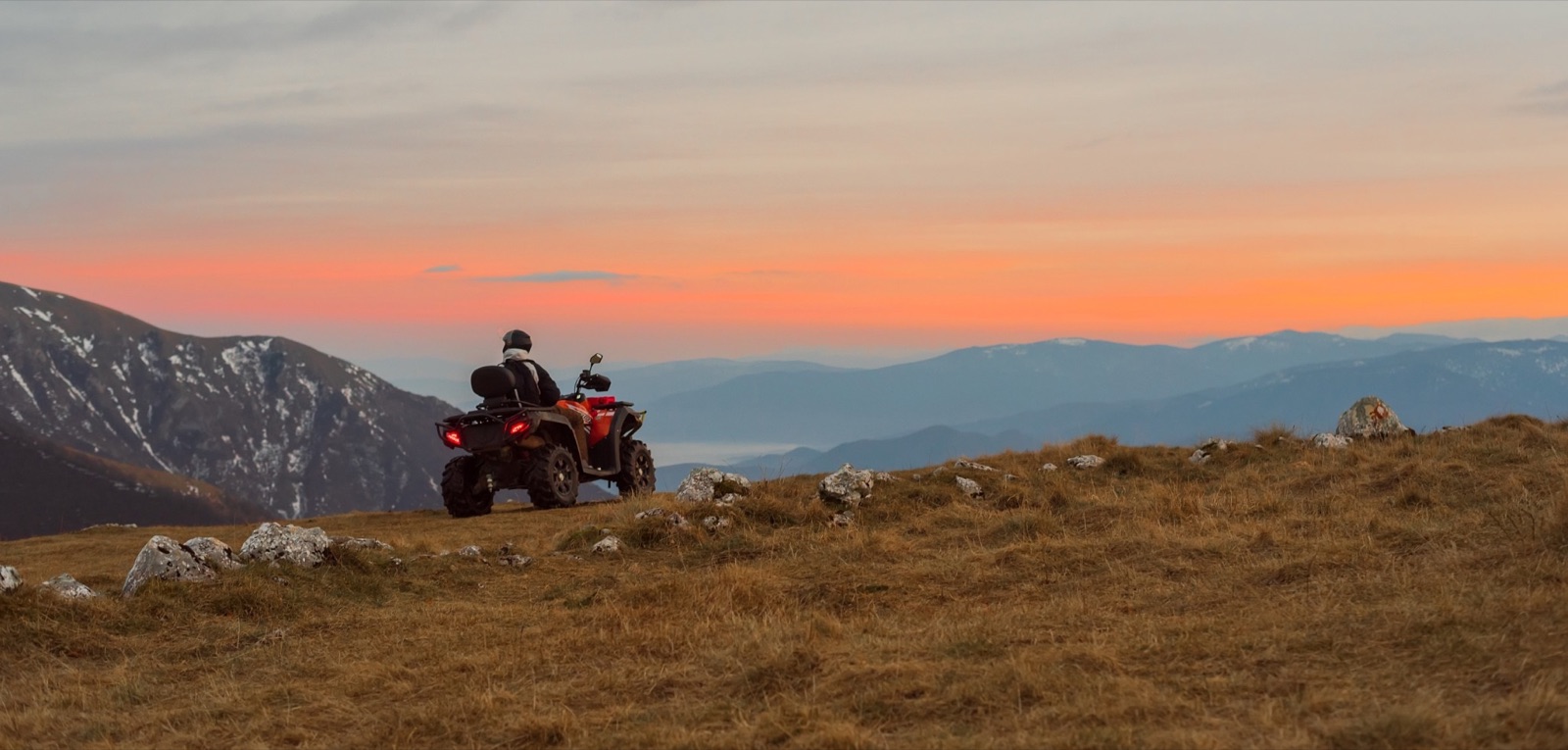 ATV parked on a mountain ridge at sunset — ATV loan refinancing