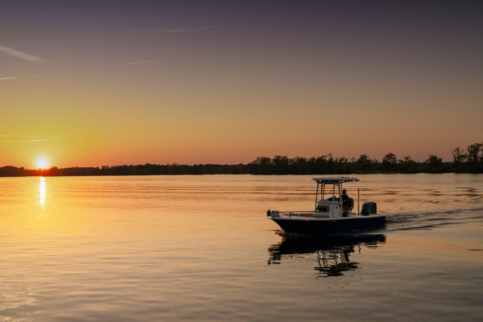 Boat crossing calm water at sunset — boat loan refinancing