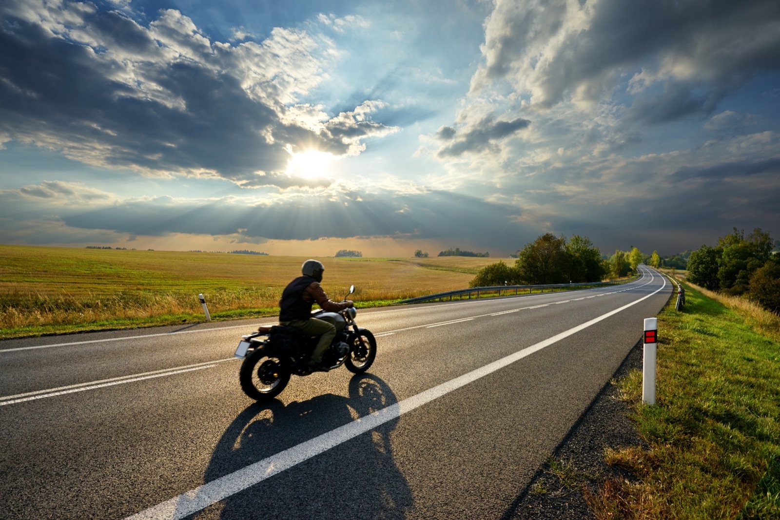 Motorcycle rider on an open road at sunset — motorcycle refinancing
