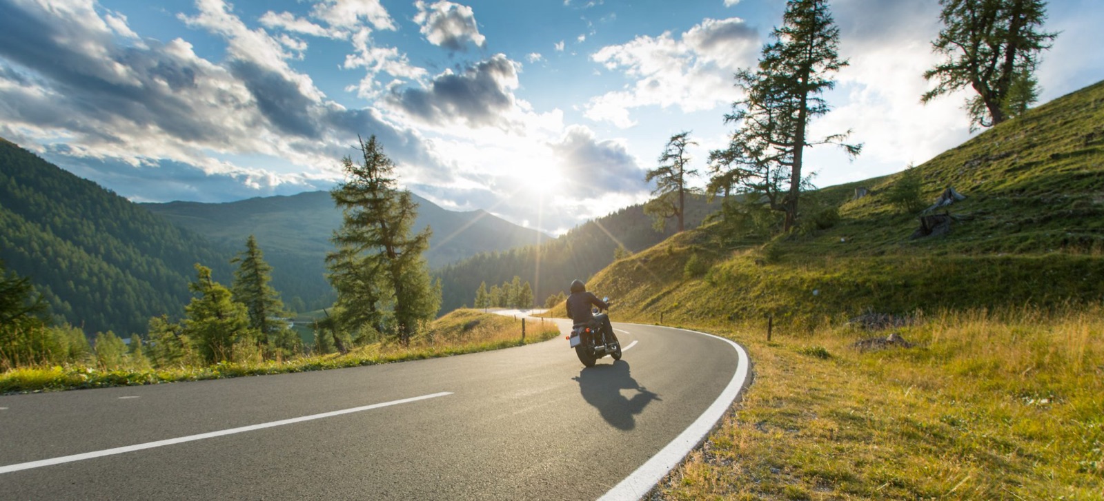 Motorcycle rider on an open mountain road after refinancing a motorcycle loan