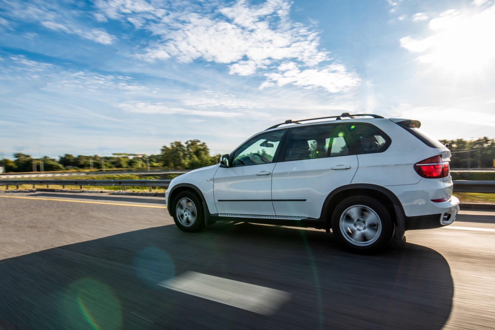 White SUV on the highway — auto loan refinancing